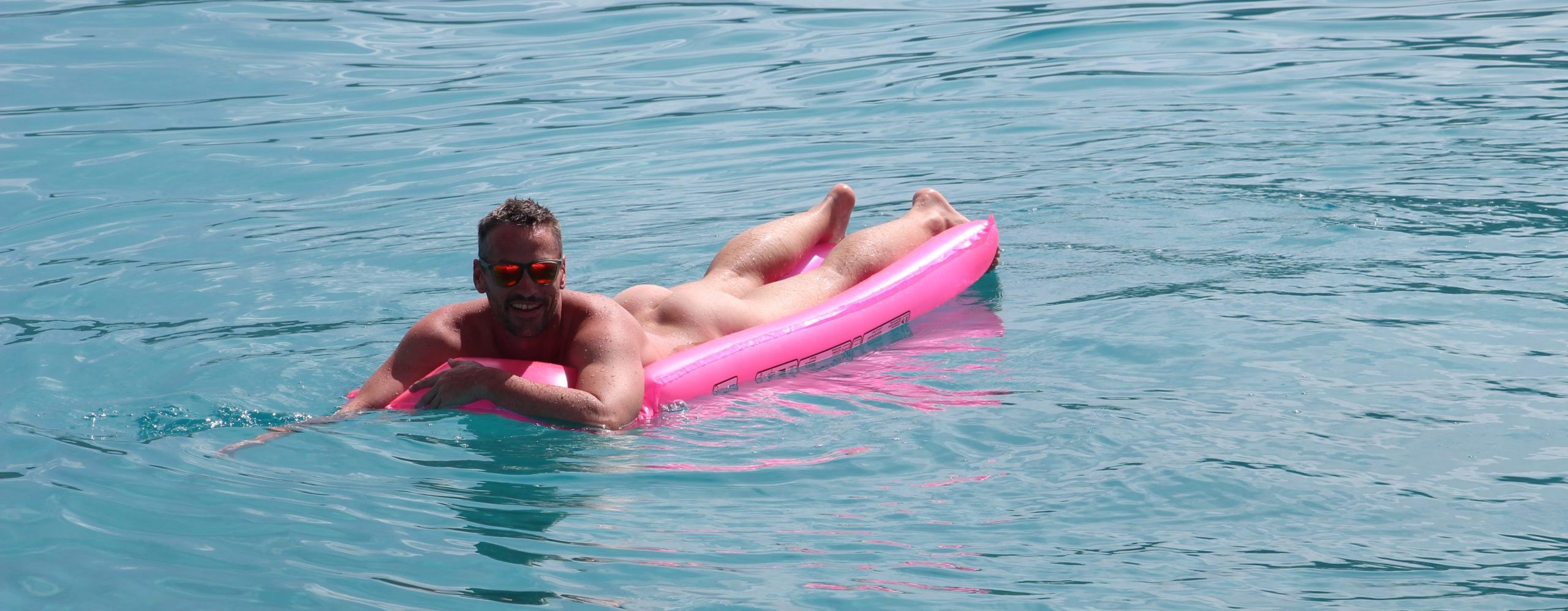 Saltyboys skipper Ross naked on airbed Tahiti