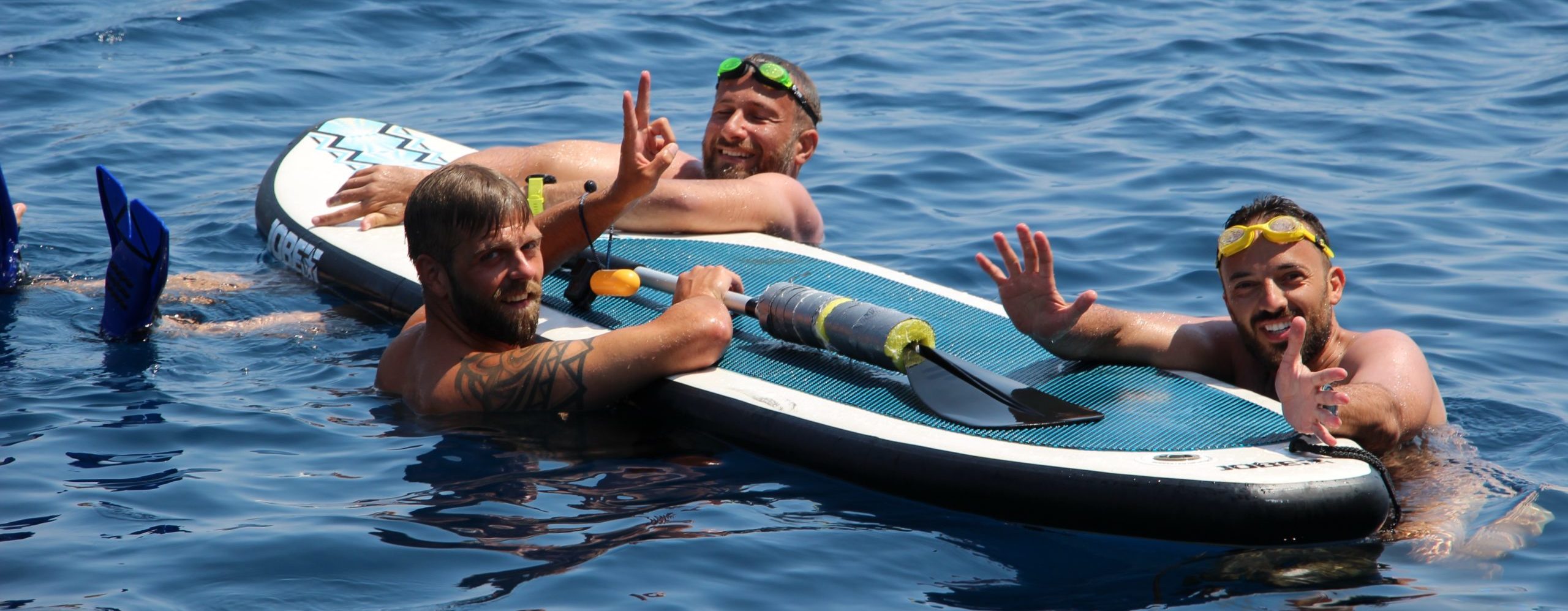 Saltyboys gay socialising in the sea on SUP peddle board